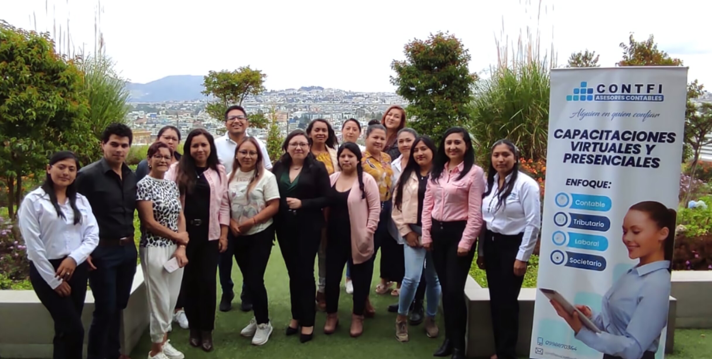 Grupo de participantes de una capacitación de CONTFI junto al banner de la empresa en una terraza de Quito